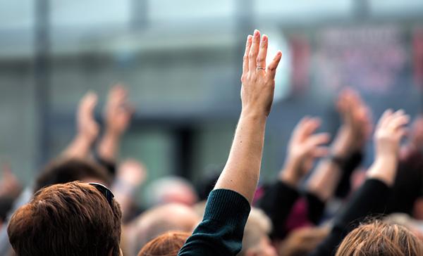 Crowd of people all raising their hands