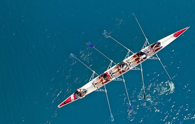 Aerial drone ultra wide photo with copy space of sport canoe with young team of athletes practising in deep blue open ocean sea