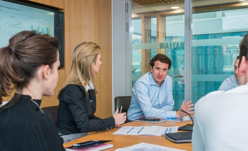 Investment professionals discussing opportunities in a meeting