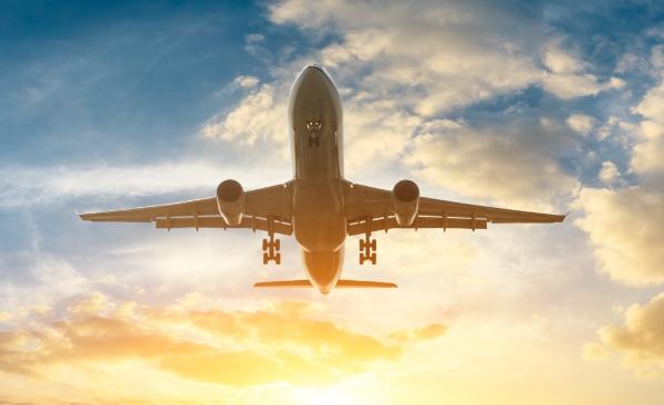 A commercial airplane taking off at dusk