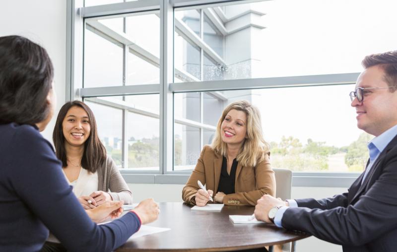 Group of Ares employees at a table talking