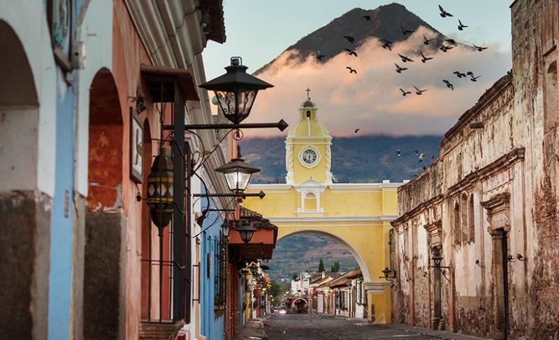 Street in Guatemala with colorful buildings and a view of a mountain